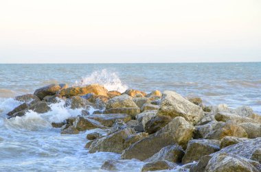 Denizin eveining içinde büyük taş olan bir görünüm
