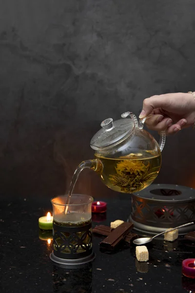 Tea pot, candles, shockolate, waffles, dark background — Stock Photo, Image