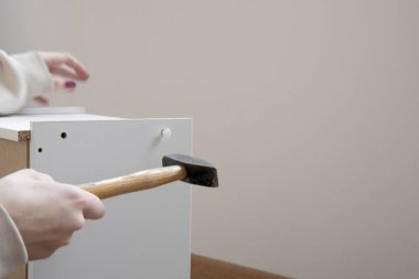 Manikürlü kadın elleri küçük dolaba saldırıyor.