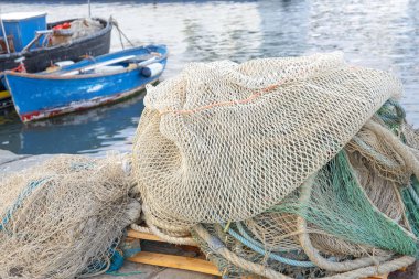 İskelede bir sürü balık ağı, tekneler