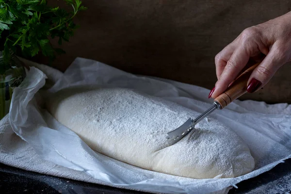 Zuur Deeg Brood Een Backing Paper Keukenhanddoek Hand Met Broodmes — Stockfoto