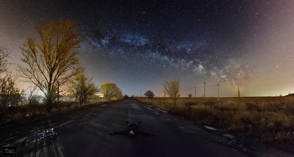 여행자 아스팔트로 포장된 바닥에 누워입니다 하늘에 하늘에 있습니다 빛나는 밤하늘 — 스톡 사진