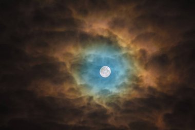 Mavi Ominously Moon bulutlar üzerinden ışıklar. Gece gökyüzü ayçiçeği