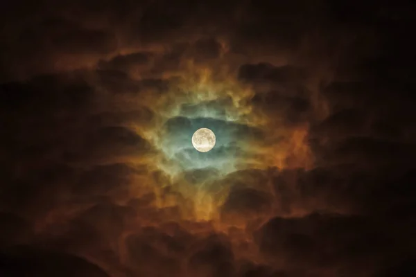 Una Luna Llena Ominentemente resalta las nubes oscuras. Cielo nocturno girasol — Foto de Stock