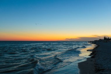 Akşamları sakin bir deniz manzarası. Mavi gökyüzü. Suda dalgalar, yakın plan.