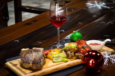 kavrulmuş sebze ve bir kadeh kırmızı şarap bir sığır eti biftek