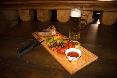 bir kupa kahverengi bira ve sebze pub ile kavrulmuş lezzetli sığır eti biftek