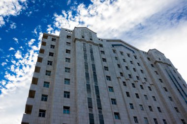 bir bulutlu gökyüzü mavi zemin üzerine beyaz bir konut/ticari modern kule