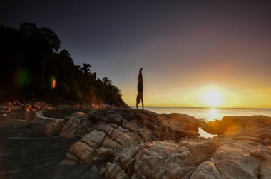 Adam yoga gün batımında