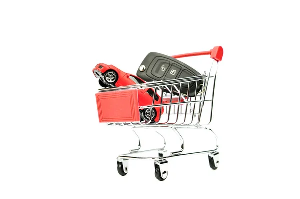 おもちゃの車と車の鍵を内に孤立した白と赤のショッピング カート — ストック写真