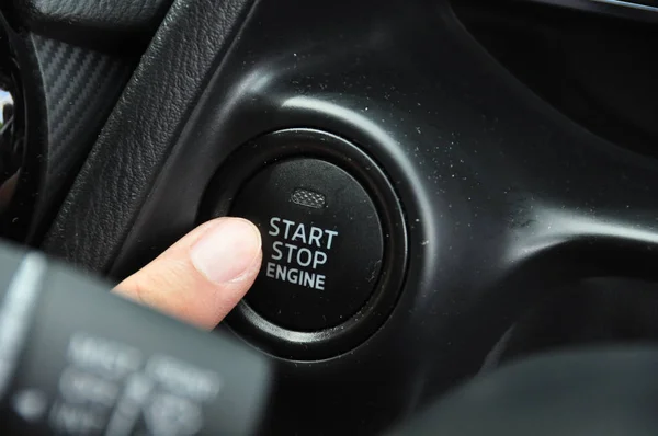 cropped shot of woman pushing start button in car