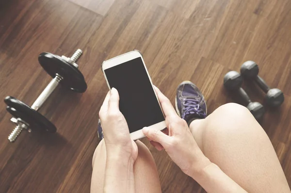 woman using smartphone at gym