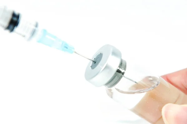 ワクチンのバイアルに注射針 ストックフォト