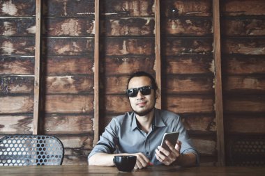 Asya adam cep telefonuyla kafede kahve içme