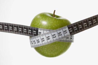 bir mezura tarafından çevrili granny smith elma
