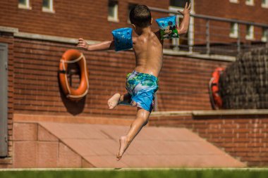 Çocuklar saltando a la piscina in vacaciones