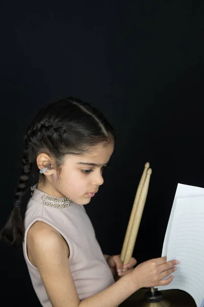 İngiliz Hint kökenli pratik ve davul çalmaya 5 yaşındaki kız yazıma - kopya alanı ile karanlık bir arka plan müzik okuma. 