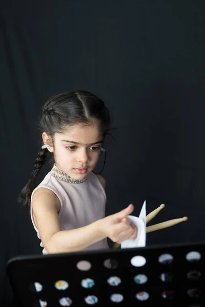 İngiliz Hint kökenli pratik ve davul çalmaya 5 yaşındaki kız yazıma - kopya alanı ile karanlık bir arka plan müzik okuma. 