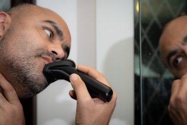 İngiliz Asya adam, onun anız veya ayna önünde, sakal Düzeltme.