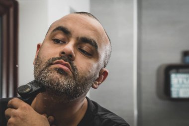 İngiliz Asya adam, onun anız veya ayna önünde, sakal Düzeltme.