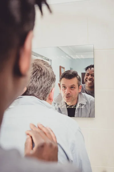 Bir gay çift banyo aynası önünde birlikte.