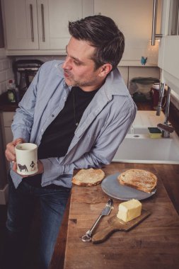 Onların gün iş yerinde gelen haberlerin bir dilim tost ve çay ve kahve bir fincan üzerinde akşam paylaşımı bir gay çift. 