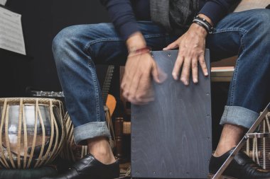 Denim ve çift keşiş ayakkabı şık bir müzisyen Cajon, Bir Perulu davul İspanya Flamenko dans ile yaygın olarak kullanılan çalış. 