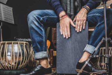Denim ve çift keşiş ayakkabı şık bir müzisyen Cajon, Bir Perulu davul İspanya Flamenko dans ile yaygın olarak kullanılan çalış. 