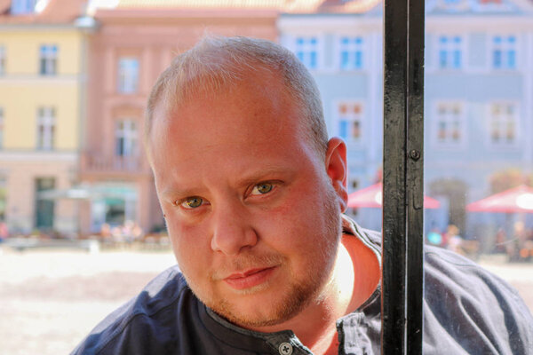 толстый молодой человек с блондинистым портретом
