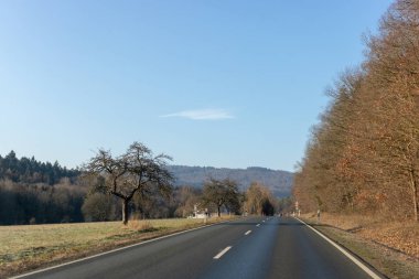 Alanları ve Almanya kışın ağaçlar arasındaki kıvrımlı yol 