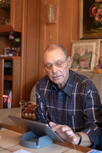 Homem Idoso Focado Usando Tablet Casa — Fotografia de Stock