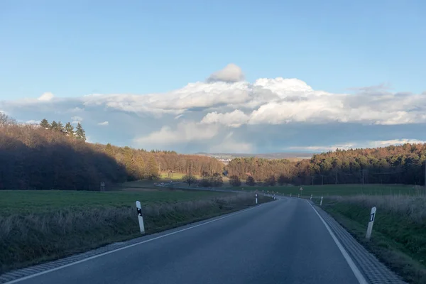 Gebogen weg tussen velden en bomen in Duitsland — Stockfoto