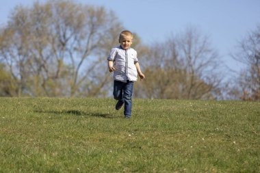 Sevimli çocuk çim und gülümseyen genelinde çalışan.