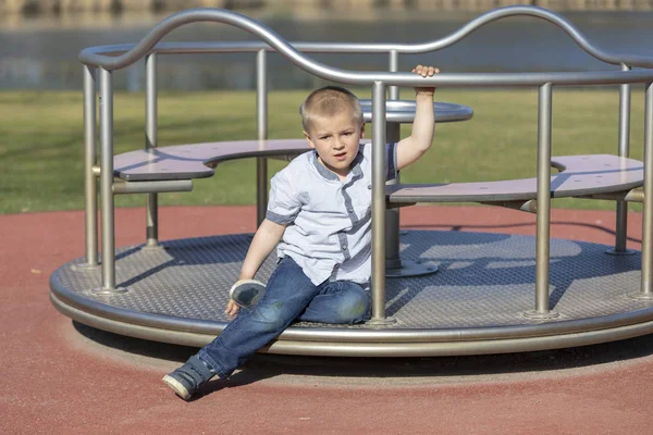 Little boy on a playground. Child playing outdoors in summer. Ki