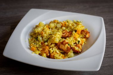 Et, biber, sebze ve baharatlı paella.