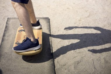 Plajda güneşli havalarda denge tahtası üzerinde dengeleme