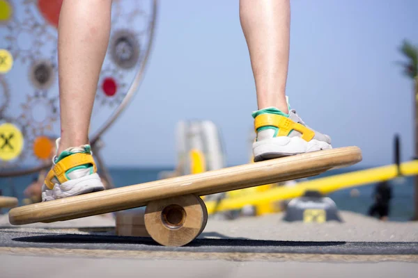 Balancing on a balance board in sunny weather at the beach