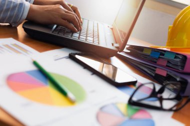 Laptop ve ticaret veri grafik belgesi ile Ofis Masası üzerinde çalışan kadın elleri. İş ve Office hayat kavramı.