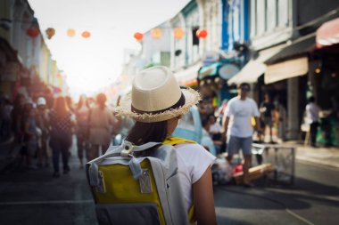 Sırt çantası thalang yol kalabalık turist olan phuket, chino Portekiz tarzı bina, Tayland arasında küçük kız arkasından görünümü ile yürüyüş ile küçük kız.