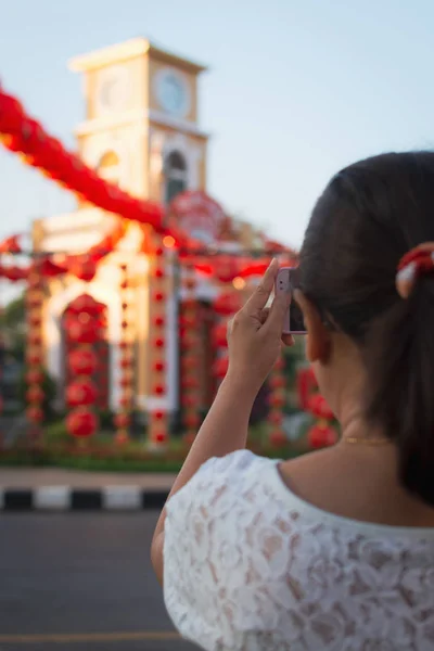 女旅行者在钟楼用手机拍照 在泰国普吉岛用红色的中国灯笼装饰 — 图库照片