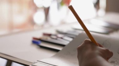 Masa, Sanat ve eğitim kavramı üzerinde renkli kalem ile bir kitapta küçük kız boyama resim El.