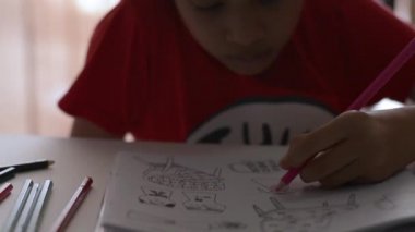 Masa, Sanat ve eğitim kavramı üzerinde renkli kalem ile bir kitapta küçük kız boyama resmi.