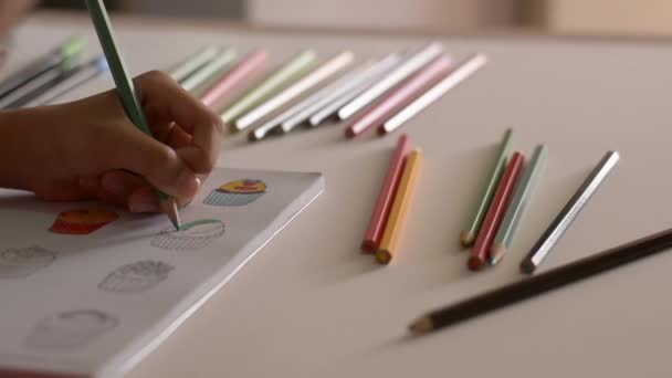 Main de petite fille coloriage image dans un livre avec crayon de couleur sur le bureau, Art et concept d'éducation .