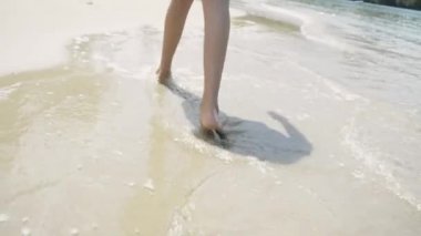 Küçük kız yaz aylarında sığ su ile plajda çıplak ayak yürüme.