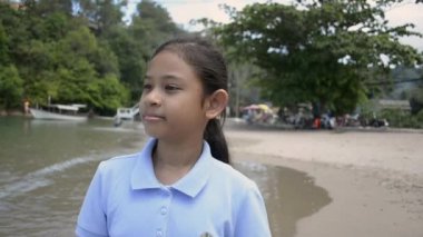 Sevimli kız yaz aylarında sahilde mutlu bir şekilde yürüyüş, Yavaş hareket.