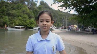 Sevimli kız yaz aylarında sahilde mutlu bir şekilde yürüyüş, Yavaş hareket.