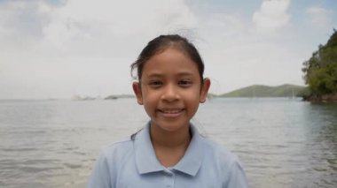 Yaz aylarında sahilde gülümseyen sevimli kız yakın portresi.