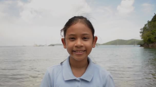 夏の間にビーチで微笑むかわいい女の子のクローズアップポートレート — ストック動画