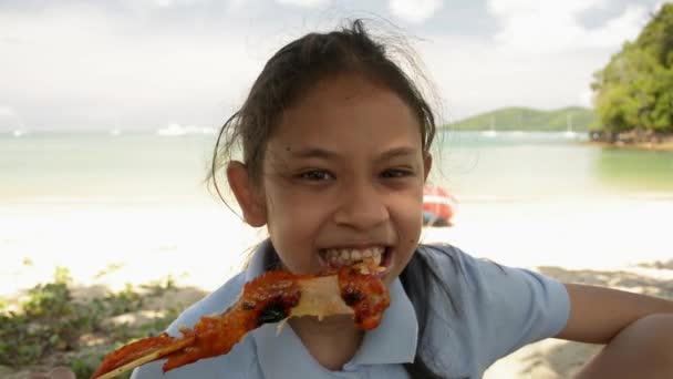 Niña Comiendo Deliciosa Ala Pollo Parrilla Bajo Sombra Playa Durante — Vídeo de stock