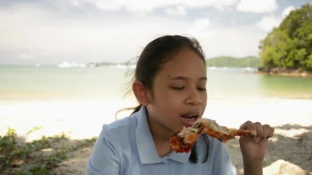 Menina Comendo Deliciosa Asa Frango Grelhado Sob Sombra Praia Durante — Vídeo de Stock